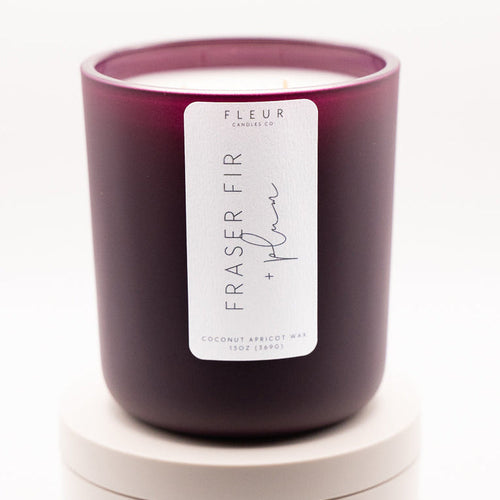 Purple candle with a label on a white background