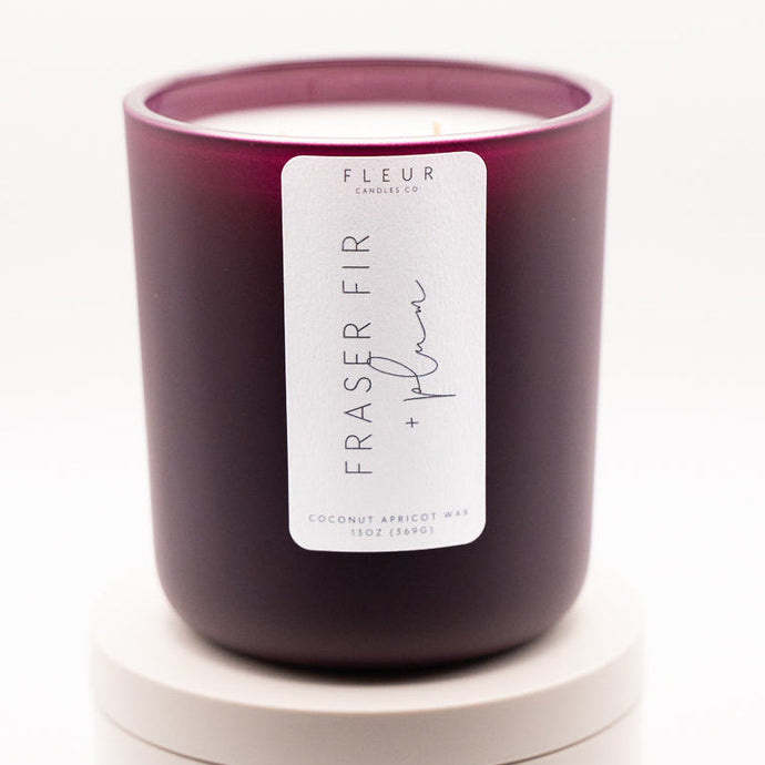 Purple candle with a label on a white background